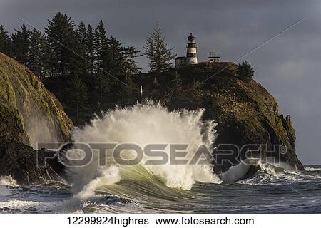Stock Photograph - A wave explodes at Cape Disappointment; Ilwaco, Washington, United States of America. Fotosearch