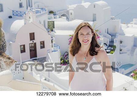A woman poses with whitewash church and buildings in the background; Santorini, Greece View Large Photo Image Stock Photo - A woman poses with whitewash church and buildings in the background; Santorini, Greece. Fotosearch