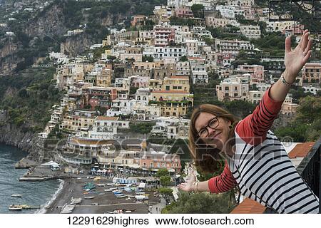 A woman posing with a view of the buildings along the Amalfi Coast; Positano, Campania, Italy View Large Photo Image Stock Photograph - A woman posing with a view of the buildings along the Amalfi Coast; Positano, Campania, Italy. Fotosearch
