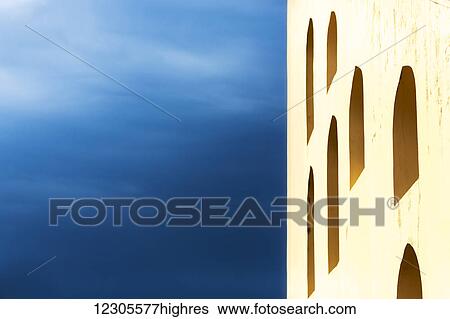 A yellow wall with arched windows and a blue sky; Jaipur, Rajasthan, India View Large Photo Image Stock Photograph - A yellow wall with arched windows and a blue sky; Jaipur, Rajasthan, India. Fotosearch