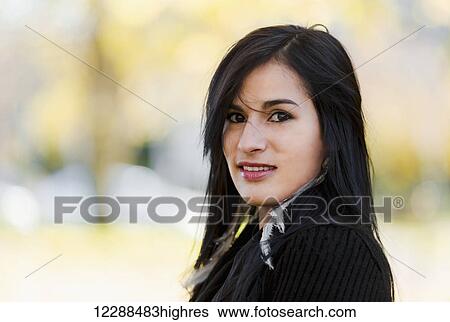 A young aboriginal female model smiles and looks at the camera in a shoulders up headshot taken in the outdoors in autumn; Vancouver, British Columbia, Canada View Large Photo Image Stock Photograph - A young aboriginal female model smiles and looks at the camera in a shoulders up headshot taken in the outdoors in autumn; Vancouver, British Columbia, Canada. Fotosearch