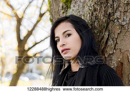 A young aboriginal female model headshot in the outdoors in autumn with a tilted gaze into the camera leaning on a tree; Vancouver, British Columbia, Canada View Large Photo Image Stock Photograph - A young aboriginal female model headshot in the outdoors in autumn with a tilted gaze into the camera leaning on a tree; Vancouver, British Columbia, Canada. Fotosearch
