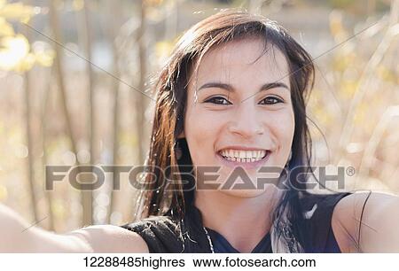 A young aboriginal female model takes a playful fun selfie outdoors in a close up headshot; Vancouver, British Columbia, Canada View Large Photo Image Stock Photograph - A young aboriginal female model takes a playful fun selfie outdoors in a close up headshot; Vancouver, British Columbia, Canada. Fotosearch