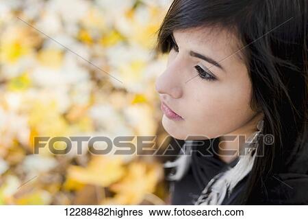 A young aboriginal female model viewed from above has a sad and contemplative distant look, looking away from the camera in an outdoor autumn setting; Vancouver, British Columbia, Canada View Large Photo Image Stock Photograph - A young aboriginal female model viewed from above has a sad and contemplative distant look, looking away from the camera in an outdoor autumn setting; Vancouver, British Columbia, Canada. Fotosearch