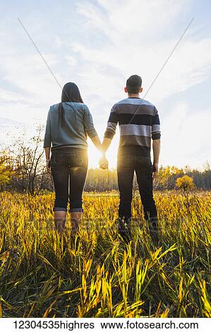 A young Asian couple enjoying quality time together outdoors in a park in autumn and holding hands in the warmth of the sunlight during the early evening; Edmonton, Alberta, Canada View Large Photo Image Stock Photograph - A young Asian couple enjoying quality time together outdoors in a park in autumn and holding hands in the warmth of the sunlight during the early evening; Edmonton, Alberta, Canada. Fotosearch
