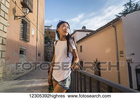 Stock Photograph - A young Chinese woman in downtown Cuenca; Cuenca, Castile-La Mancha, Spain. Fotosearch