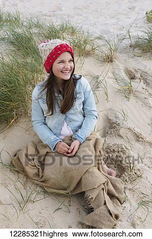 A young woman sits on a beach wearing a knit hat; Tarifa, Cadiz, Andalusia, Spain View Large Photo Image Stock Photograph - A young woman sits on a beach wearing a knit hat; Tarifa, Cadiz, Andalusia, Spain. Fotosearch