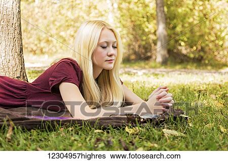 A young woman with long blond hair spending personal time in Bible study and praying outdoors in a park in autumn; Edmonton, Alberta, Canada View Large Photo Image Stock Photograph - A young woman with long blond hair spending personal time in Bible study and praying outdoors in a park in autumn; Edmonton, Alberta, Canada. Fotosearch
