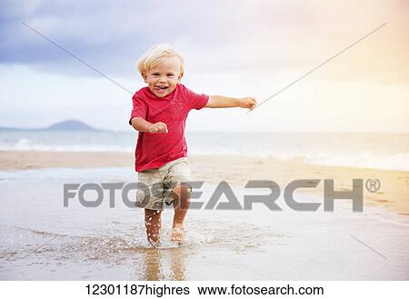 Adorable cute young boy running on the beach View Large Photo Image Stock Photograph - Adorable cute young boy running on the beach. Fotosearch