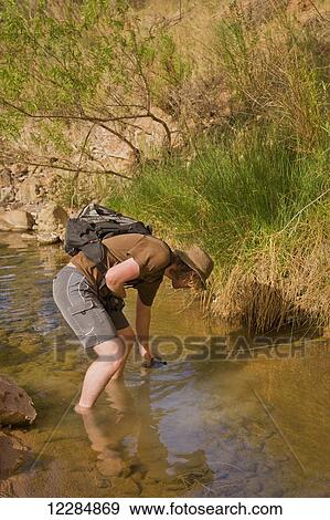 Stock Photo - Adventurer exploring a desert canyon narrows, Capitol Reef National Park; Utah, United States of America. Fotosearch