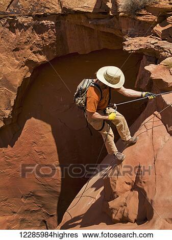 Stock Photograph - Adventurer exploring a desert slot canyon, San Rafael Swell; Utah, United States of America. Fotosearch