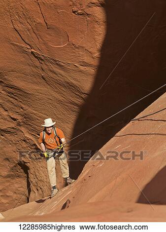 Adventurer exploring a desert slot canyon, San Rafael Swell; Utah, United States of America View Large Photo Image Stock Photograph - Adventurer exploring a desert slot canyon, San Rafael Swell; Utah, United States of America. Fotosearch
