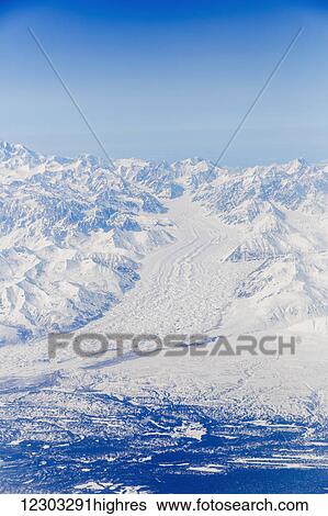 Stock Photograph - Aerial view of a snow covered Buckskin Glacier running into the foreground, Alaska Range, Interior Alaska, USA, Winter. Fotosearch