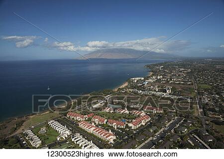 Stock Photograph - Aerial view of condominiums, Kihei and Wailea, a sailboat and the West Maui mountains; Kihei, Maui, Hawaii, United States of America. Fotosearch