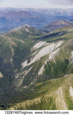 Stock Photograph - Aerial view of mountain ridges and green valleys in the Brooks Range; Alaska, United States of America. Fotosearch