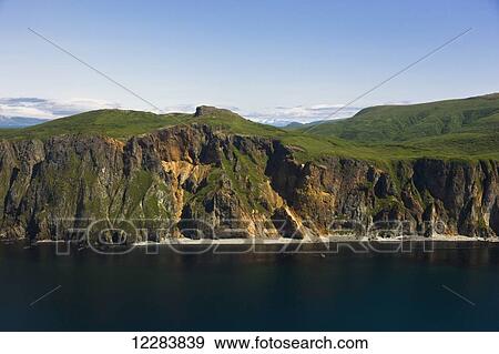 Aerial view of rocky cliffs and green hills along the shore of Popof Island near Sand Point, Southwestern Alaska, USA, Summer View Large Photo Image Stock Photo - Aerial view of rocky cliffs and green hills along the shore of Popof Island near Sand Point, Southwestern Alaska, USA, Summer. Fotosearch