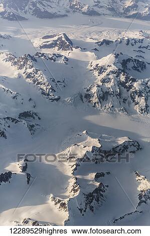 Stock Photograph - Aerial view of snow covered mountains and snow fields in the Coastal Range, Southeast Alaska, USA, Summer. Fotosearch