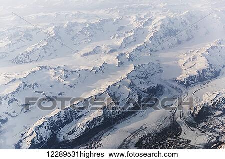 Stock Photograph - Aerial view of snow covered mountains and glaciers in the Coastal Range, Southeast Alaska, USA, Summer. Fotosearch