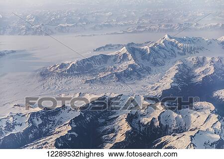 Stock Photograph - Aerial view of snow covered mountains and glaciers in the Coastal Range, Southeast Alaska, USA, Summer. Fotosearch