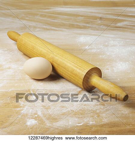 Stock Photograph - An egg and rolling pin on a floured surface; Toronto, Ontario, Canada. Fotosearch