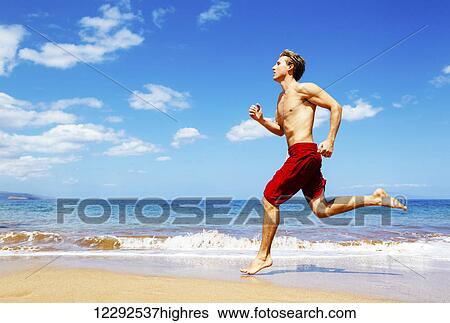 Stock Photograph - Athletic Man Running on Beach. Fotosearch