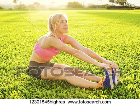Attractive fit young woman stretching before exercise, sunrise early morning backlit. Healthy lifestyle sports fitness concept. View Large Photo Image Stock Photograph - Attractive fit young woman stretching before exercise, sunrise early morning backlit. Healthy lifestyle sports fitness concept.. Fotosearch