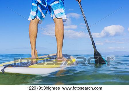 Stock Photograph - Attractive Young Man Stand Up Paddle Surfing In Hawaii, Beautiful Tropical Ocean, Active Beach Lifestyle. Fotosearch