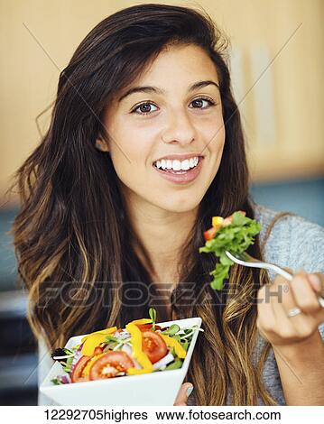 Attractive young woman eating salad View Large Photo Image Stock Photograph - Attractive young woman eating salad. Fotosearch