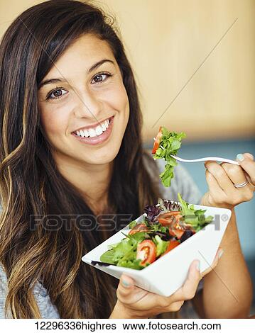 Attractive young woman eating salad View Large Photo Image Stock Photograph - Attractive young woman eating salad. Fotosearch