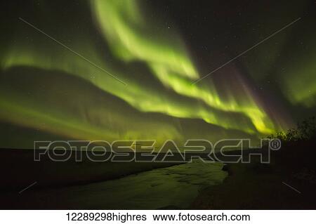 Stock Photograph - Aurora borealis over a small stream; Iceland. Fotosearch