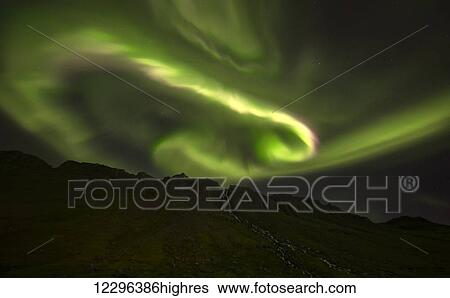Stock Photograph - Aurora overtop of an unnamed waterfall near the town of Djupavik; West Fjords, Iceland. Fotosearch
