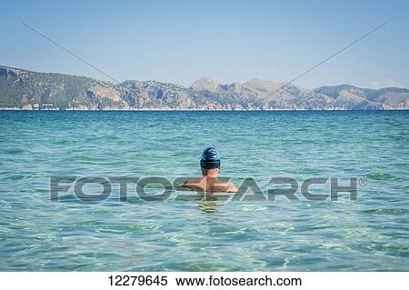 Stock Photography - Back of a male swimmer; Cala Sant Joan, Alcudia, Mallorca, Spain. Fotosearch