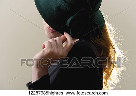 Backlit redhead hiding face behind green hat; Caldecott, England View Large Photo Image Stock Photograph - Backlit redhead hiding face behind green hat; Caldecott, England. Fotosearch