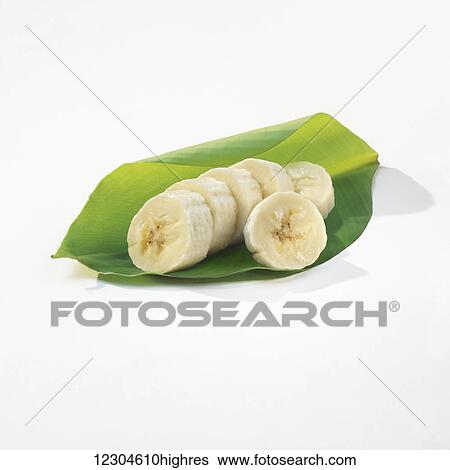 Stock Photograph - Banana slices wrapped in a green leaf on a white background; Toronto, Ontario, Canada. Fotosearch