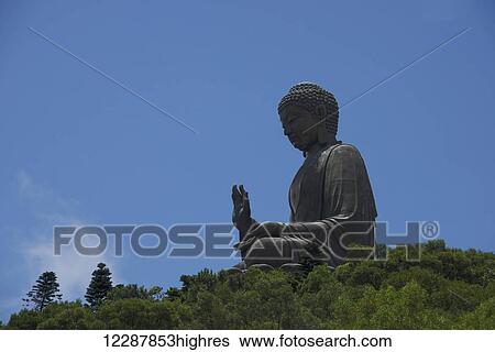 Stock Photograph - Big Buddha Against Blue Sky In Forest; Hong Kong. Fotosearch