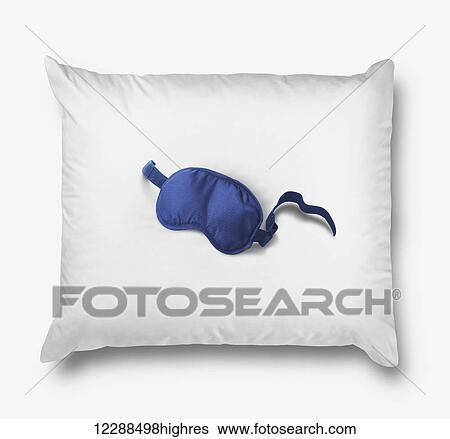 Stock Photograph - Blue sleeping mask on a pillow; Toronto, Ontario, Canada. Fotosearch