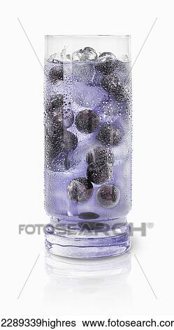 Stock Photograph - Blueberries floating in a drinking glass with blue beverage and ice cubes against a white background; Toronto, Ontario, Canada. Fotosearch