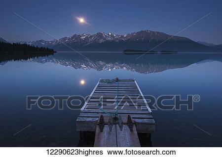 Boat dock with a full moon rising over the Chigmit Mountains at Lake Clark in Lake Clark National Park and Preserve, Alaska. View Large Photo Image Stock Photograph - Boat dock with a full moon rising over the Chigmit Mountains at Lake Clark in Lake Clark National Park and Preserve, Alaska.. Fotosearch