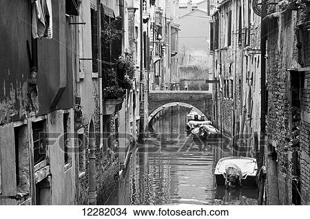Picture - Boats moored along buildings in a tranquil canal; Venice, Italy. Fotosearch