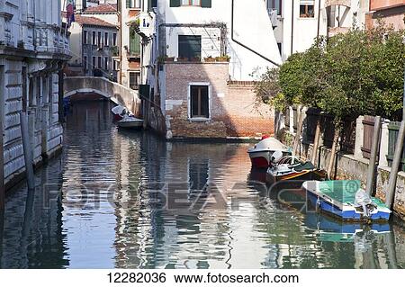 Stock Photograph - Boats moored in the tranquil canal; Venice, Italy. Fotosearch