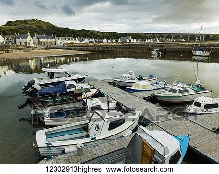 Boats moored in the tranquil harbour of the North Sea with houses in the background; Cullen, Moray, Scotland View Large Photo Image Stock Photograph - Boats moored in the tranquil harbour of the North Sea with houses in the background; Cullen, Moray, Scotland. Fotosearch
