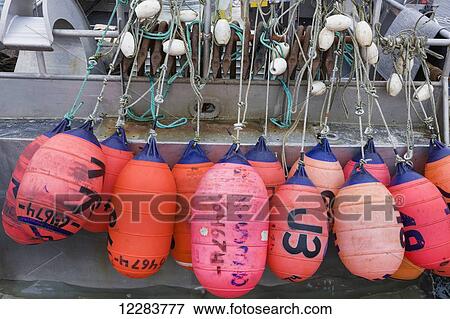Stock Photo - Bouys hang off a Boat in St. Paul Harbor, St. Paul Island, Southwestern Alaska, USA, Summer. Fotosearch