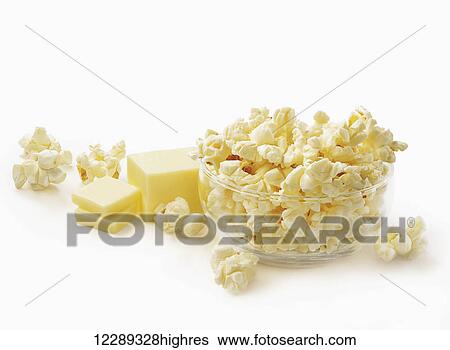 Stock Photograph - Bowl of popcorn with block of cut butter on a white background; Toronto, Ontario, Canada. Fotosearch