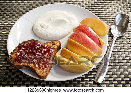 Stock Photograph - Breakfast of yogurt, toast and sliced apple, Tofino Chalet, Jensen's Bay; Tofino, British Columbia, Canada. Fotosearch