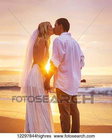 Bride and Groom, Enjoying Amazing Sunset on a Beautiful Tropical Beach, Romantic Married Couple Kissing View Large Photo Image Stock Photograph - Bride and Groom, Enjoying Amazing Sunset on a Beautiful Tropical Beach, Romantic Married Couple Kissing. Fotosearch