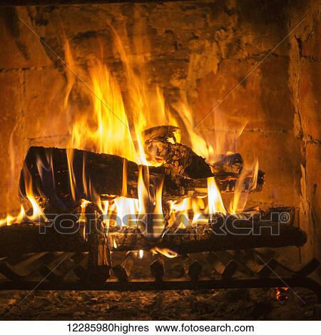 Stock Photograph - Bright orange and yellow flames in a burning fire in a fireplace; San Miguel de Allende, Guanajuato, Mexico. Fotosearch