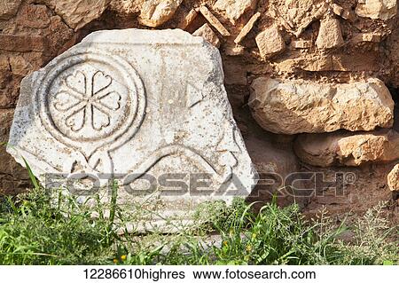 Stock Photograph - Broken stone structure with a floral design; Delphi, Greece. Fotosearch