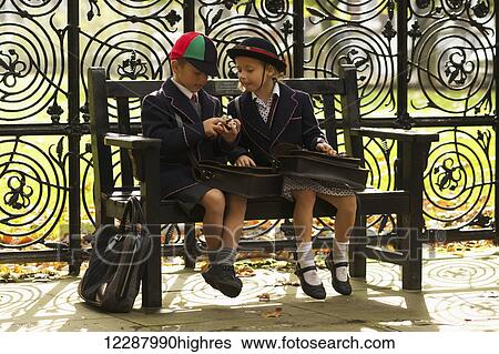 Brother and sister in school uniforms eating on wooden bench; London, England View Large Photo Image Stock Photograph - Brother and sister in school uniforms eating on wooden bench; London, England. Fotosearch