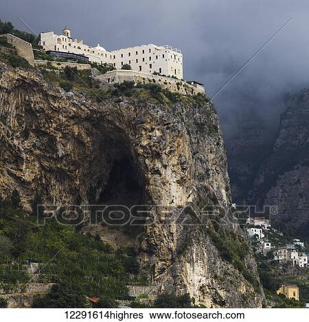 Stock Photograph - Buildings on the top of a cliff along the Amalfi coast; Amalfi, Italy. Fotosearch