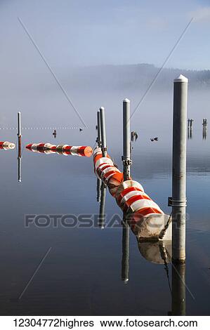 Stock Photograph - Buoys and pilings on foggy lake; Bellingham, Washington, United States of America. Fotosearch